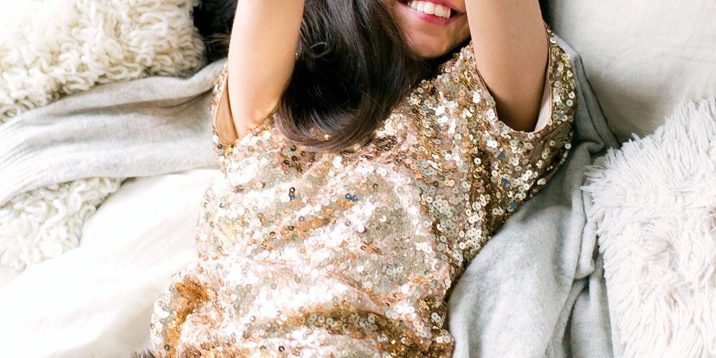 woman-wearing-brown-sequin-dress-laying-on-the-bed-698864